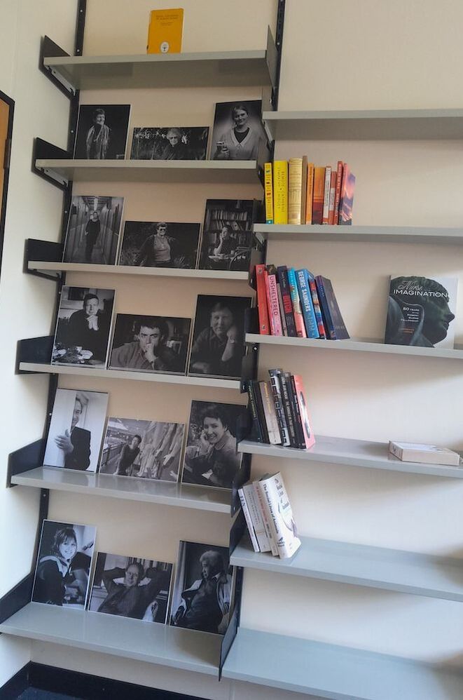 Images of past fellows on a book case